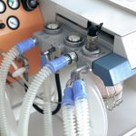 A close-up of a ventilator with tubes running into it.