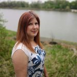 Genevieve Thompson poses by a river.