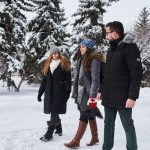 three students walk across campus in the snow