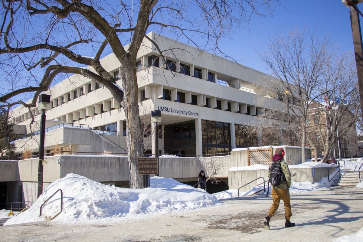 A student walks in front of UMSU University Centre on a winter day