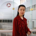 Asper School of Business student Sirius Zhang wearing a red shirt in the Drake building atrium.