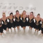 Members of Ice Intrepid stand in a semi circle on the ice smiling