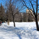 Person walks on the path along the Quad with Tier Building in the background in winter 2022. // Photo from Jack Rach