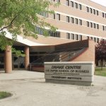 Exterior of Asper School of Business Drake Building. It has a signage and the building is made of rust coloured bricks.