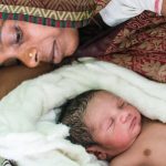 Mother looks at her new born baby.