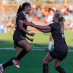 Mavignier and teammate jump in celebration on the soccer field, wearing Bisons jerseys