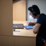 Student in mask studies for exam