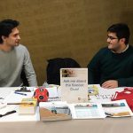 Liam Grenier and Akbar Rizvi sit behind a table in the ALC, smiling