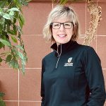 Kerri Chase smiles, wearing a black long sleeve