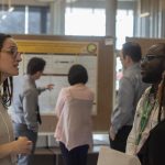 A presenter discusses their research at a previous Research Day