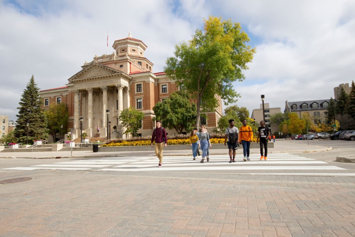 A group of students walking on a cross walk in front of the Admin building towards UMSU University Centre