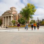 A group of students walking on a cross walk in front of the Admin building towards UMSU University Centre