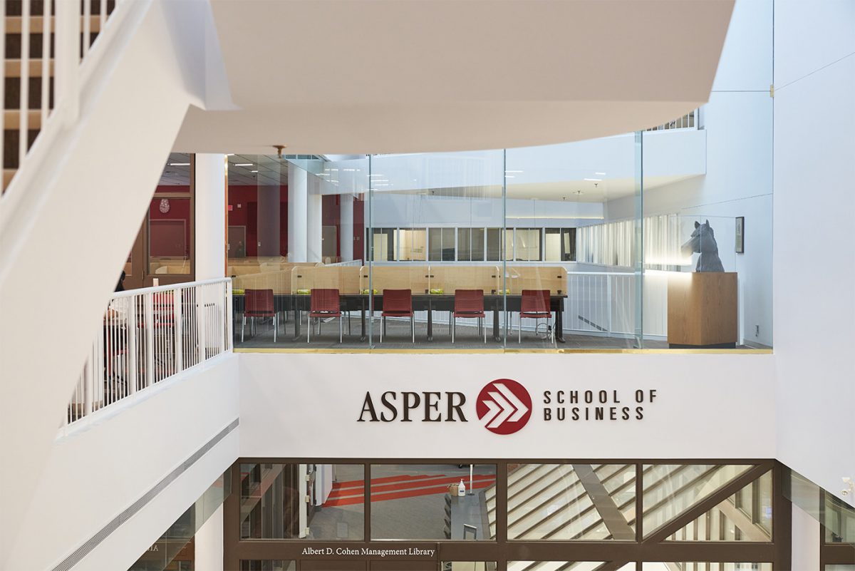 View from the third floor of the Drake Centre. Looking from the balcony, across the way is a study area with glass around it and a sign that says Asper School of Business.
