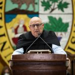 Dr. Brian Postl stands at the podium, speaking at 2022 Spring Convocation.