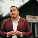Photo of William Prince standing in front of church.