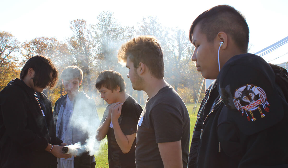 Archive photo of students taking part in a smudging ceremony (Lower Fort Garry)