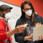 Student and instructor looking at laptop together