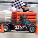 A UMSAE formula car being driven by a student