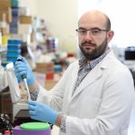 Berardino Petrelli, wearing a lab coat and gloves, working in the research lab.