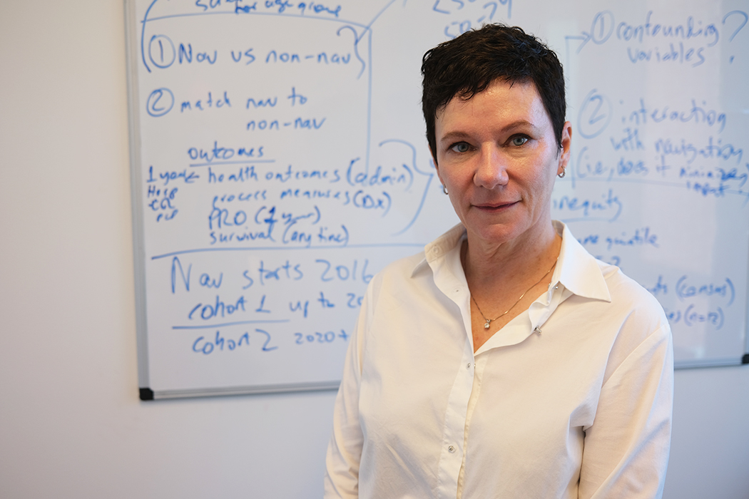 Portrait of Dr. Kathleen Decker. A whiteboard with blue writing all over it is in the background.