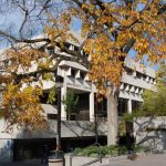 UMSU University Centre in the fall. The leaves on the trees in front of the building have turned a yellow-orange and some have already fallen.