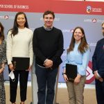 Three women and two men dressed in suits standing in a row.