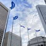 UM Homecoming flags flying at Portage and Main intersection in Winnipeg.
