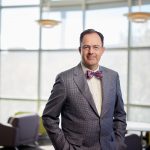 Peter Nickerson in a suit in front of windows