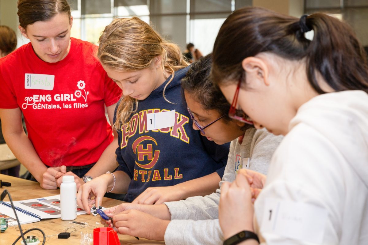 Four girls working with their hands on a mini engineering project at go Eng Girl.