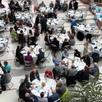 alumni sitting at tables in brodie atrium for dean's breakfast