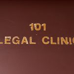 Close up image of door sign that says 101 Legal Clinic