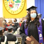 A female Indigenous student walks proudly after receiving her degree at convocation.