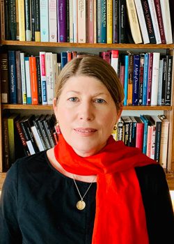 A headshot of Heidi Marx in front of a bookshelf full of books.