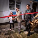 Ribbon is cut by three officials in front of learning hub.