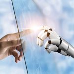 Photo of a human hand touching a robot hand.