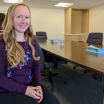 Portrait of alumna Elizabeth Stoesz seated at her desk.