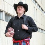 Keenan Karish walks in front of university building.