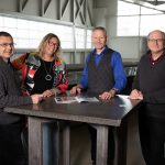 Four staff members standing around a table in the Engineering Building