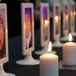 A feature image of a lit candle alongside a framed photo of one of the Cole polyetcnique victims.