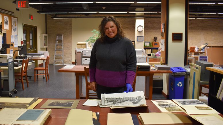 Head, Archives & Special Collections Heather Bidzinski alongside pieces from the archives.