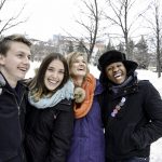 Smiling group of four students outdoors in winter.
