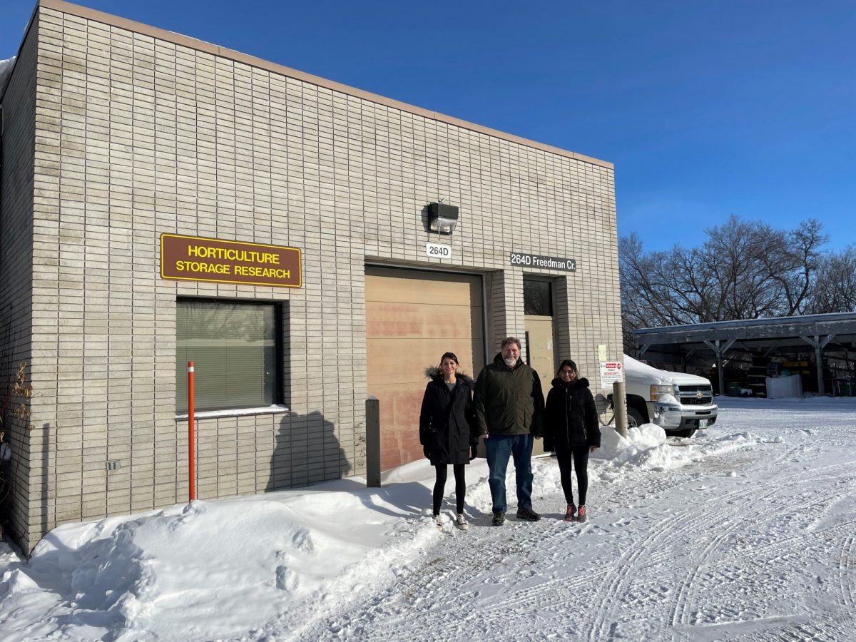 Fernanda Gouvea Pereira, senior technician, Dr. Mario Tenuta, NSERC/WGRF/Fertilizer Canada Industrial Research Chair in 4R Nutrient Stewardship And Professor of Applied Soil Ecology, Department of Soil Science and Shrinal Patel, technician stand in front of the UM Horticultural Storage Facility.