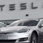 Tesla car in front of a Tesla dealership