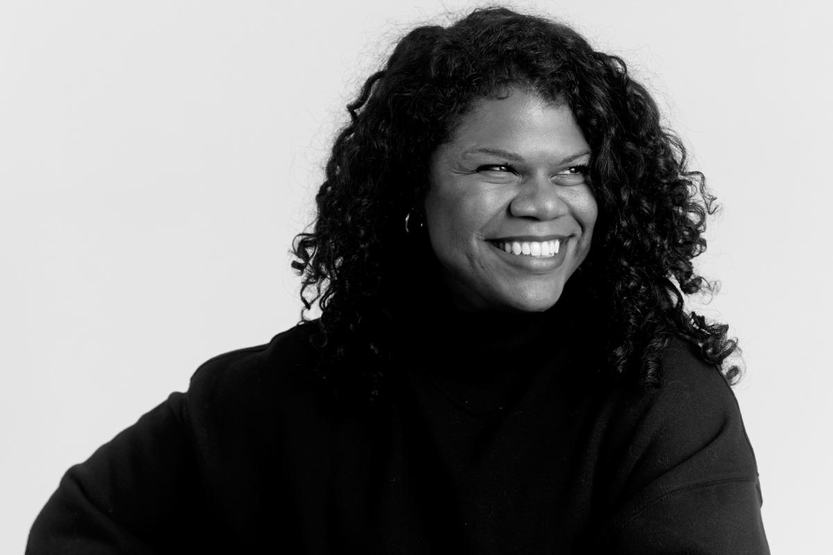 Eternity Martis smiles brightly in black and white photo.