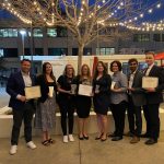 Eight individuals standing with certificates.