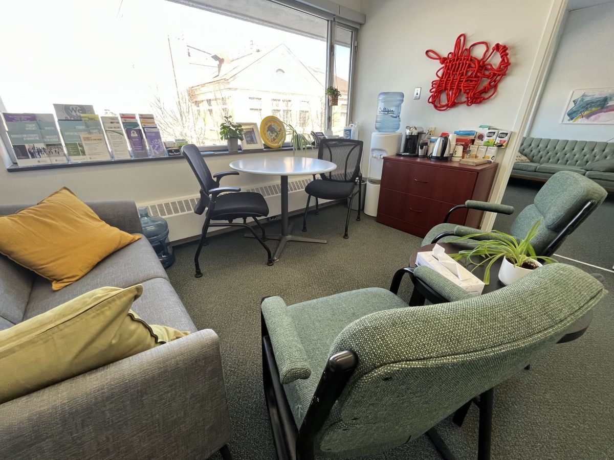 The SVRC's office welcome space is full of comfy chairs and colourful pillows, helpful pamphlets. A selection of teas are lined up beside a kettle. There is red rope art displayed on the wall. It is comfortable and inviting.