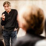 Gabor Mate speaks before a crowd.