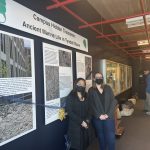 Two women standing in front of museum exhibit.