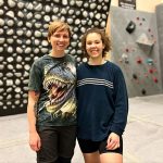 Climbers posing for picture in front of the Kilter Board