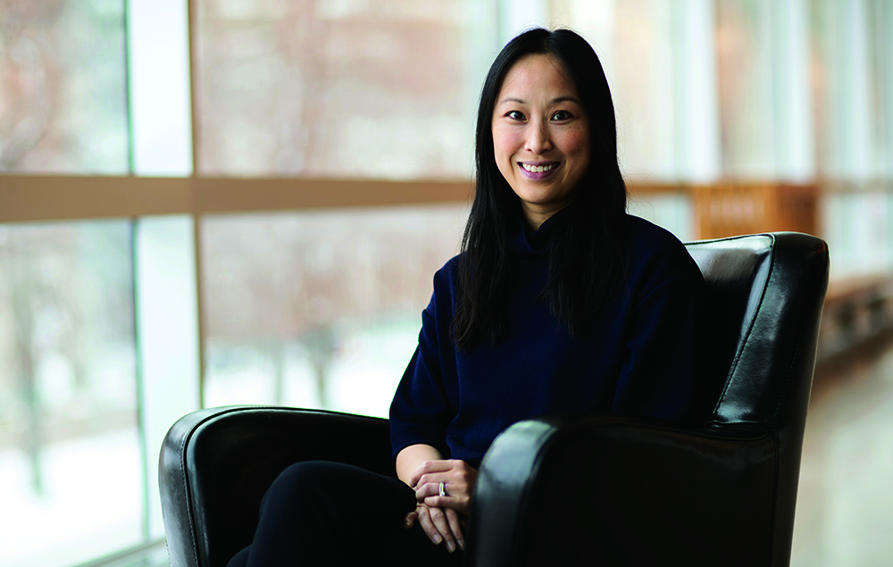 Profile of Christine Leong sitting in a chair.